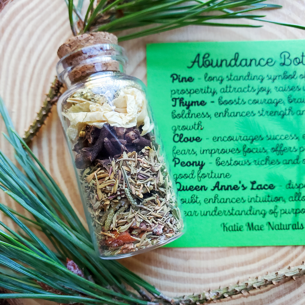 Herbal mixture in a glass bottle with a label on a wooden surface. Abundance Spell Bottle, Intention Setting Herbs for Prosperity and Sucess