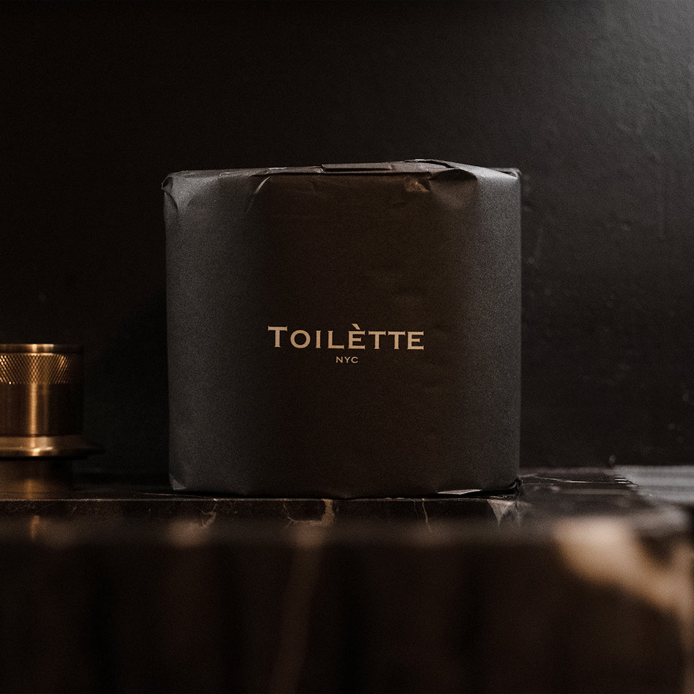Black toiletry bag with 'TOILETTE NYC' branding on a dark background. 100% Premium Bamboo Toilètte Rolls: Tree-free, lab-tested and 100% free of PFAS, formaldehyde, and elemental chlorine.