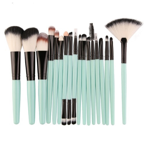 Set of makeup brushes with green handles on a white background