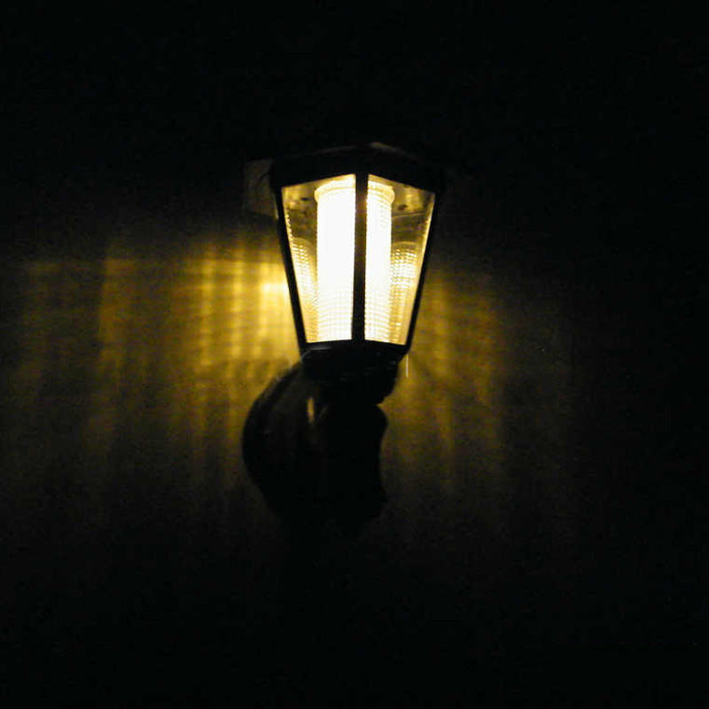 Vintage-style wall-mounted light fixture casting a warm glow in the dark.