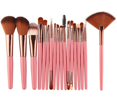 Set of makeup brushes with pink handles and rose gold ferrules on a white background