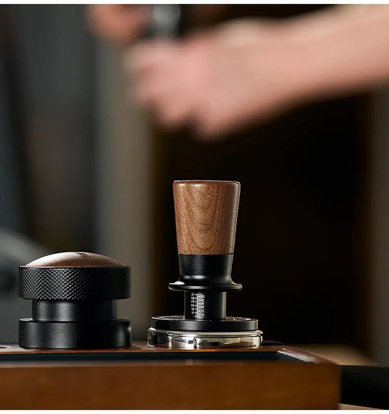 Muyu constant force spring espresso tamper with walnut wood handle, stainless steel base and self-leveling design for consistent coffee tamping pressure and smooth espresso extraction.