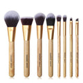 Set of makeup brushes with wooden handles and gold accents on a white background