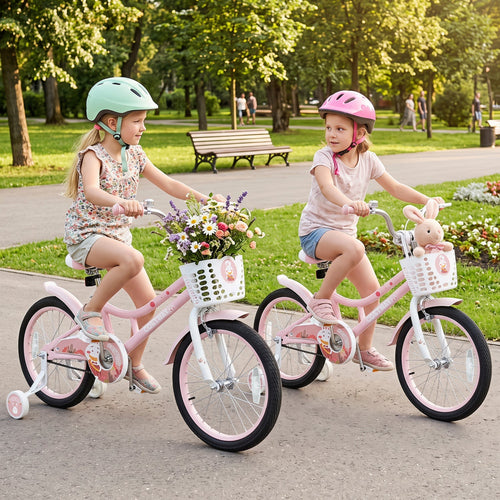 Two young girls riding pink children's bicycles in a sunny park. The bike on the left is white and pink with a flower basket, and the bike on the right is white and pink with a bunny head decoration.