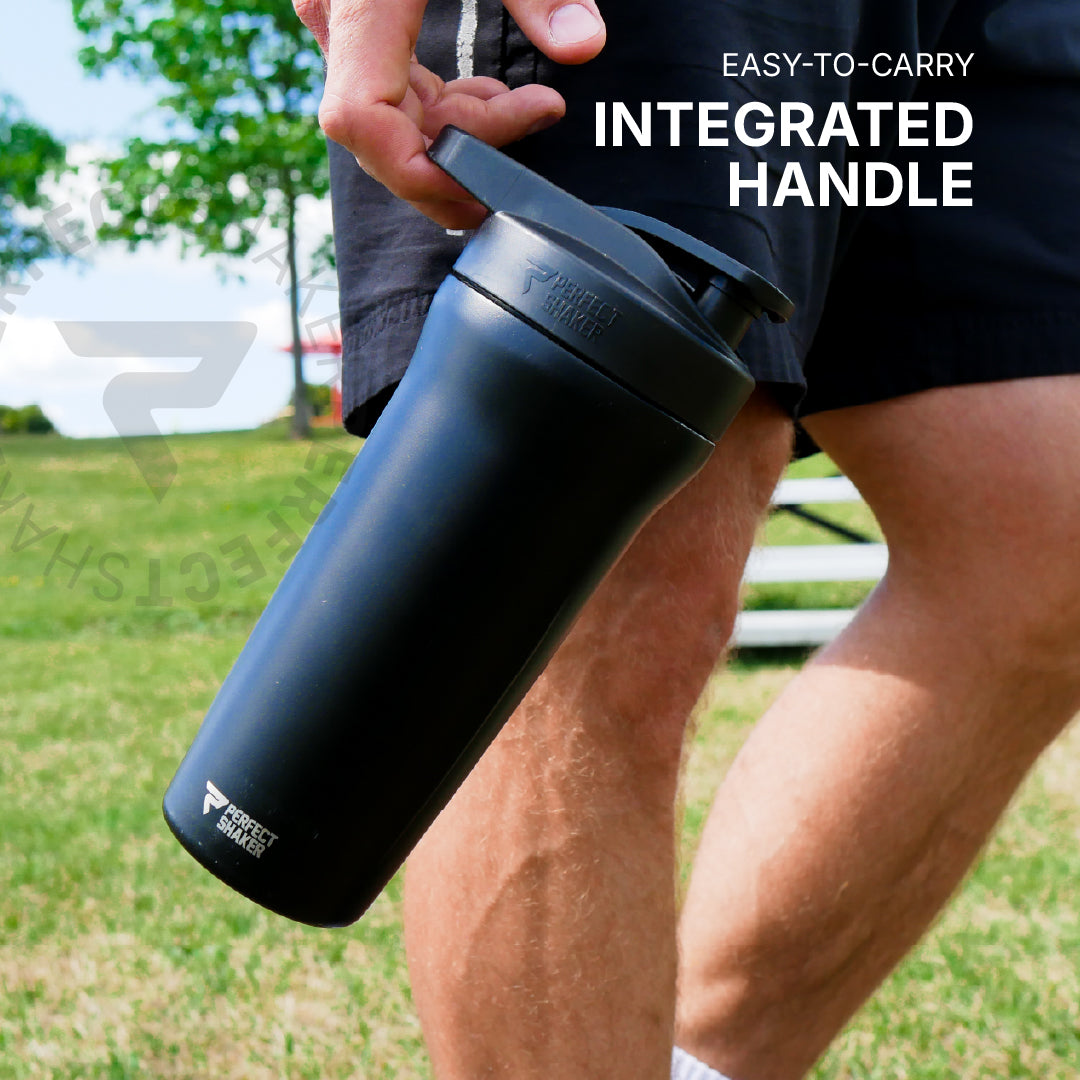 A person outdoors holding a matte black protein shaker bottle with an integrated handle. The image features text overlays reading 'EASY-TO-CARRY INTEGRATED HANDLE' and a faint brand watermark.