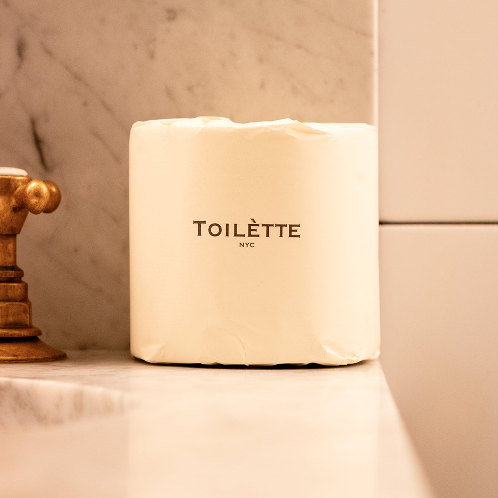 TOILETTE NYC product on a marble surface with a neutral background. 100% Premium Bamboo Toilètte Rolls: Tree-free, lab-tested and 100% free of PFAS, formaldehyde, and elemental chlorine.