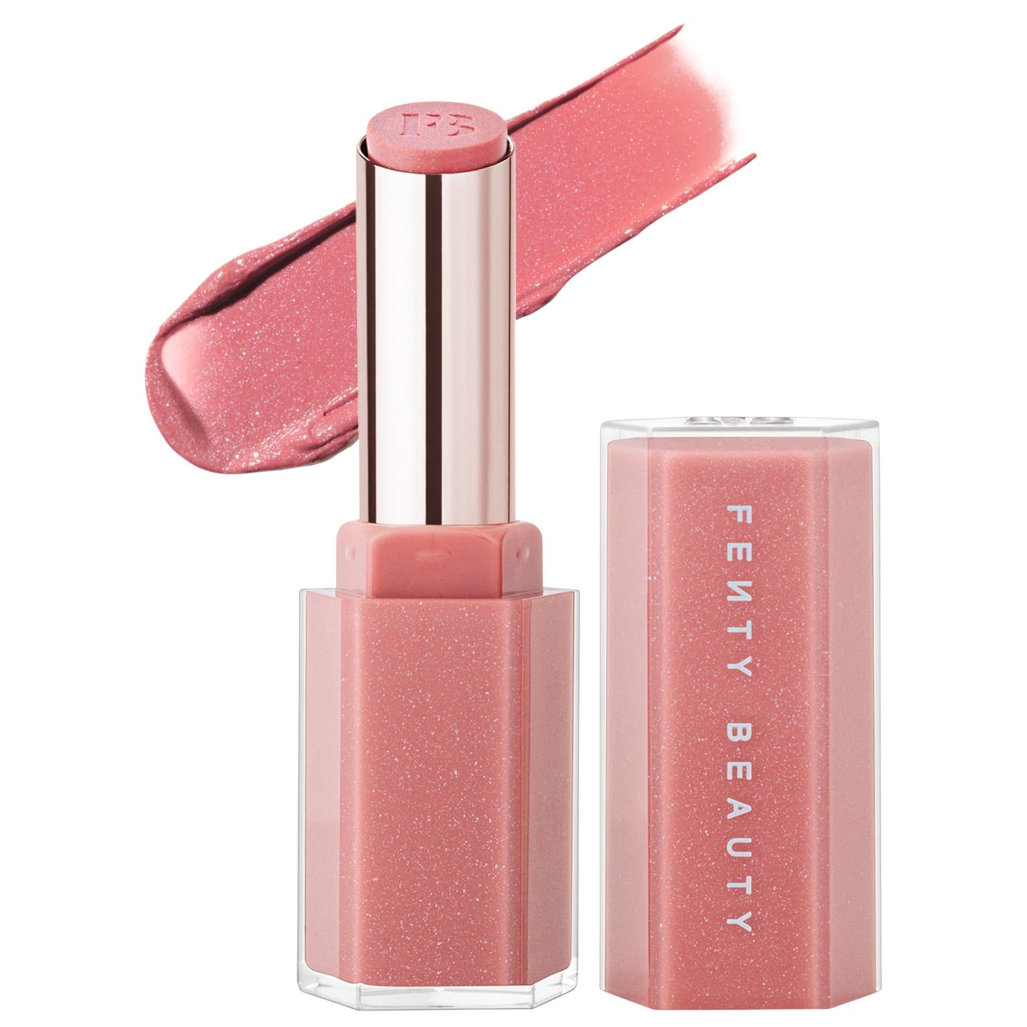 Fenty Beauty Gloss Bomb Stix high-shine gloss stick in a shimmering pink shade with matching cap and gloss swatch on a white background.