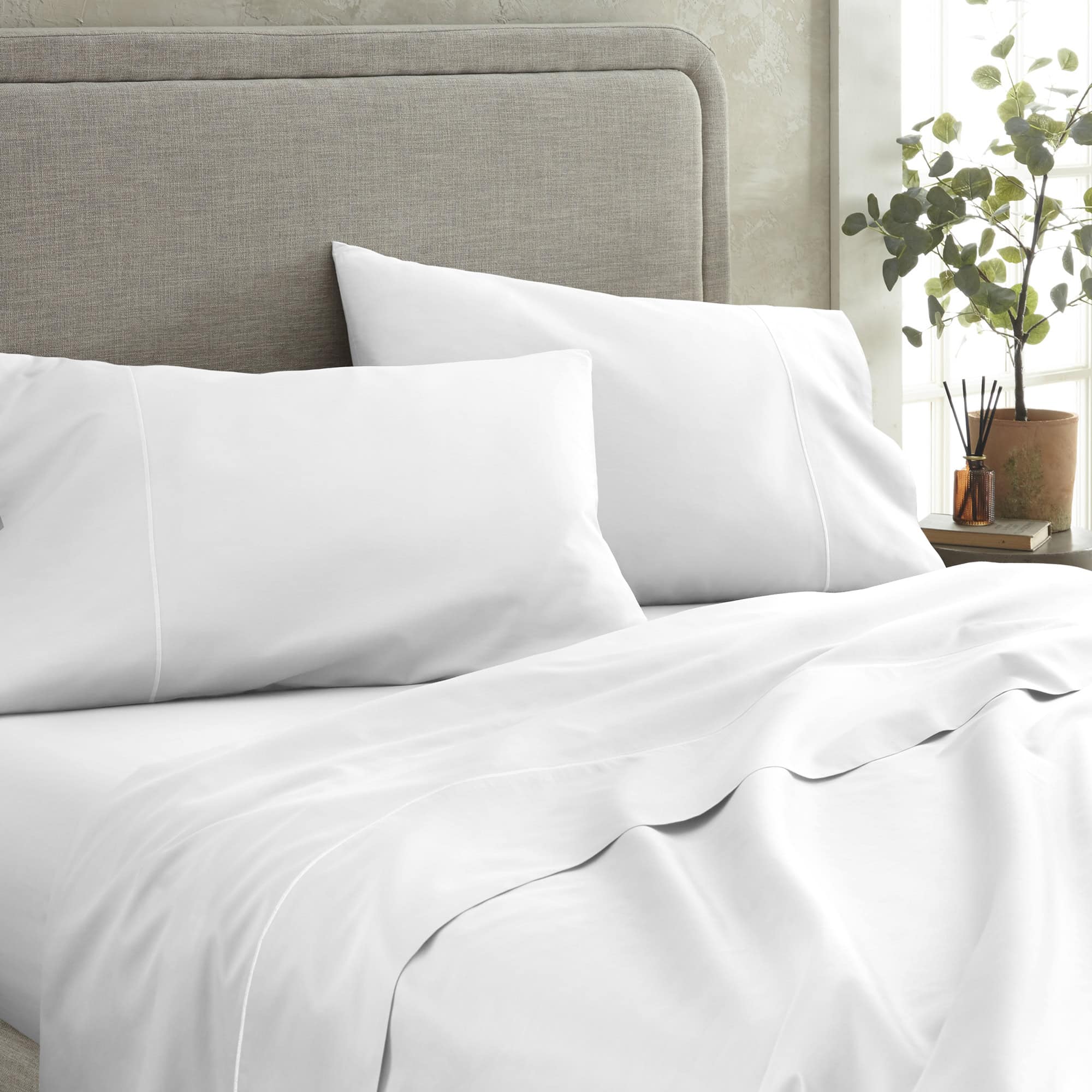 White bedding set on a bed with a gray headboard and a plant in the background. 100% GOTS-Certified &amp; Fairtrade-Certified Organic Cotton
Made in India
High quality, dense 500-thread-count sateen weave becomes luxuriously soft with washing
Durable elastic band
Non-toxic, hypoallergenic, naturally breathable, and cooling
16" deep pocket, ideal for plush mattresses
Easy Care, Machine Wash and Tumble Dry