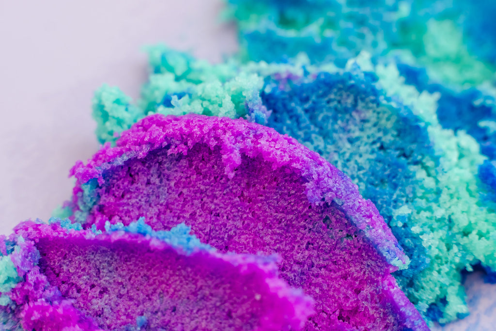 AMINNAH Galaxy Sugar Scrub close-up showcasing vibrant purple and blue exfoliating sugar crystals. Clean beauty, cruelty-free, vegan body scrub made with natural ingredients to gently exfoliate, hydrate, reduce redness, and reveal soft, glowing skin. Female-owned brand available at Tree of Life Grocers.