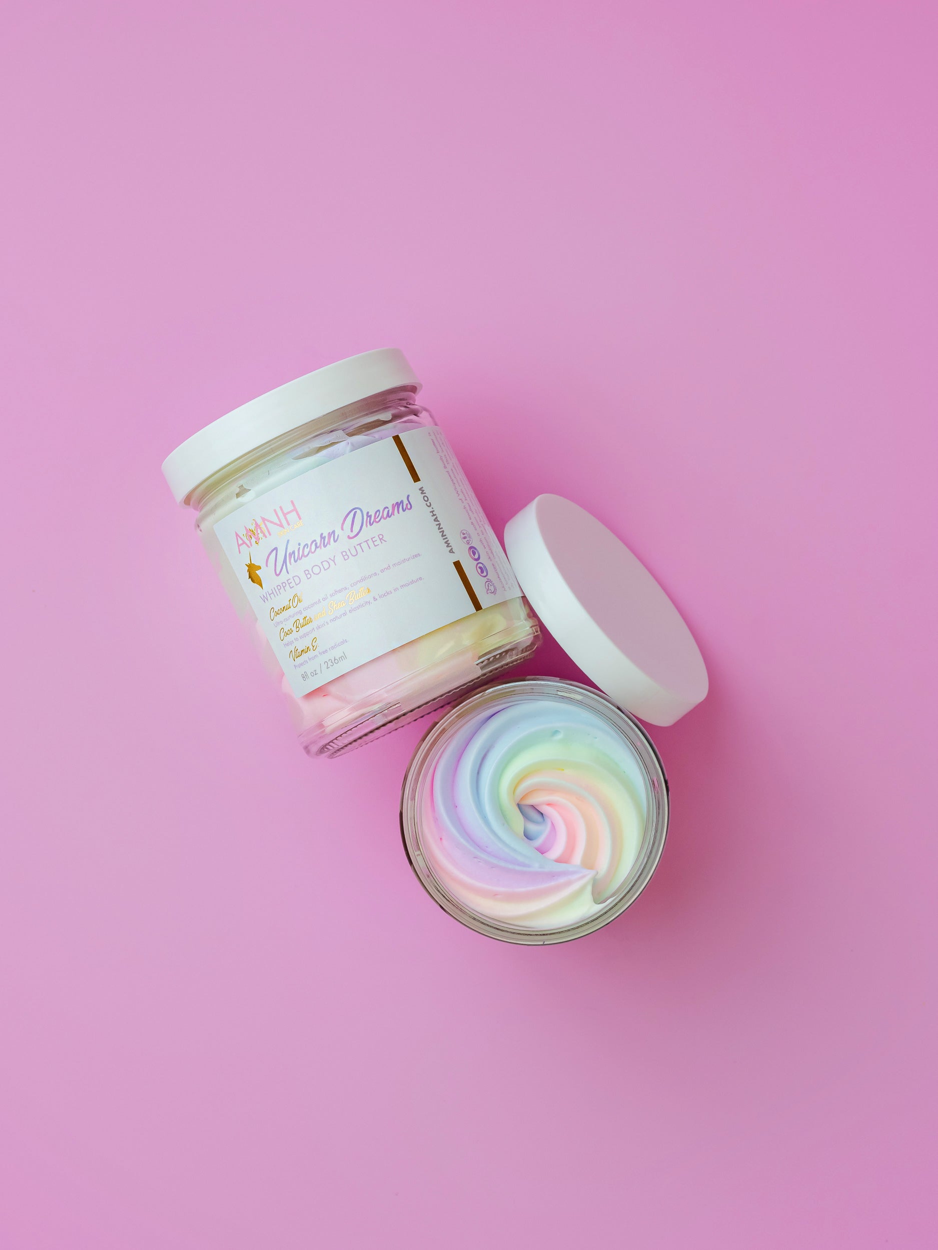 Unicorn Dreams Bundle by AMINNAH featuring whipped body butter, sugar scrub and body oil on a pink background. Clean beauty, cruelty-free, vegan skincare made with natural ingredients. Paraben-free, gluten-free and packaged in recyclable packaging. Female-owned brand offering nourishing, luxurious self-care and spa-quality body care gift set.