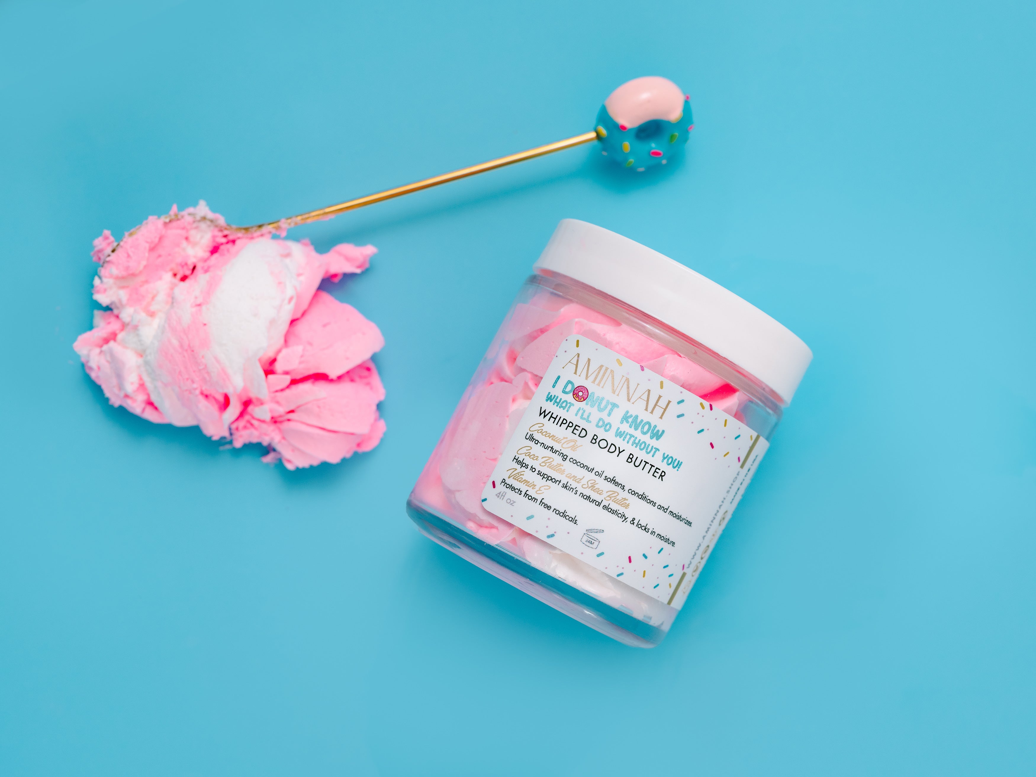 I Donut Know What I'll Do Without You! Whipped Body Butter displayed in a whimsical donut-inspired scene with pink whipped butter, a pastel dessert prop, and an 8 oz jar of rich moisturizer made with shea butter, cocoa butter, mango butter, coconut oil, jojoba oil, vitamin E, and fruit extracts to deeply nourish, soften, and hydrate dry skin. Cruelty-free, clean beauty, and perfect for daily moisturizing.