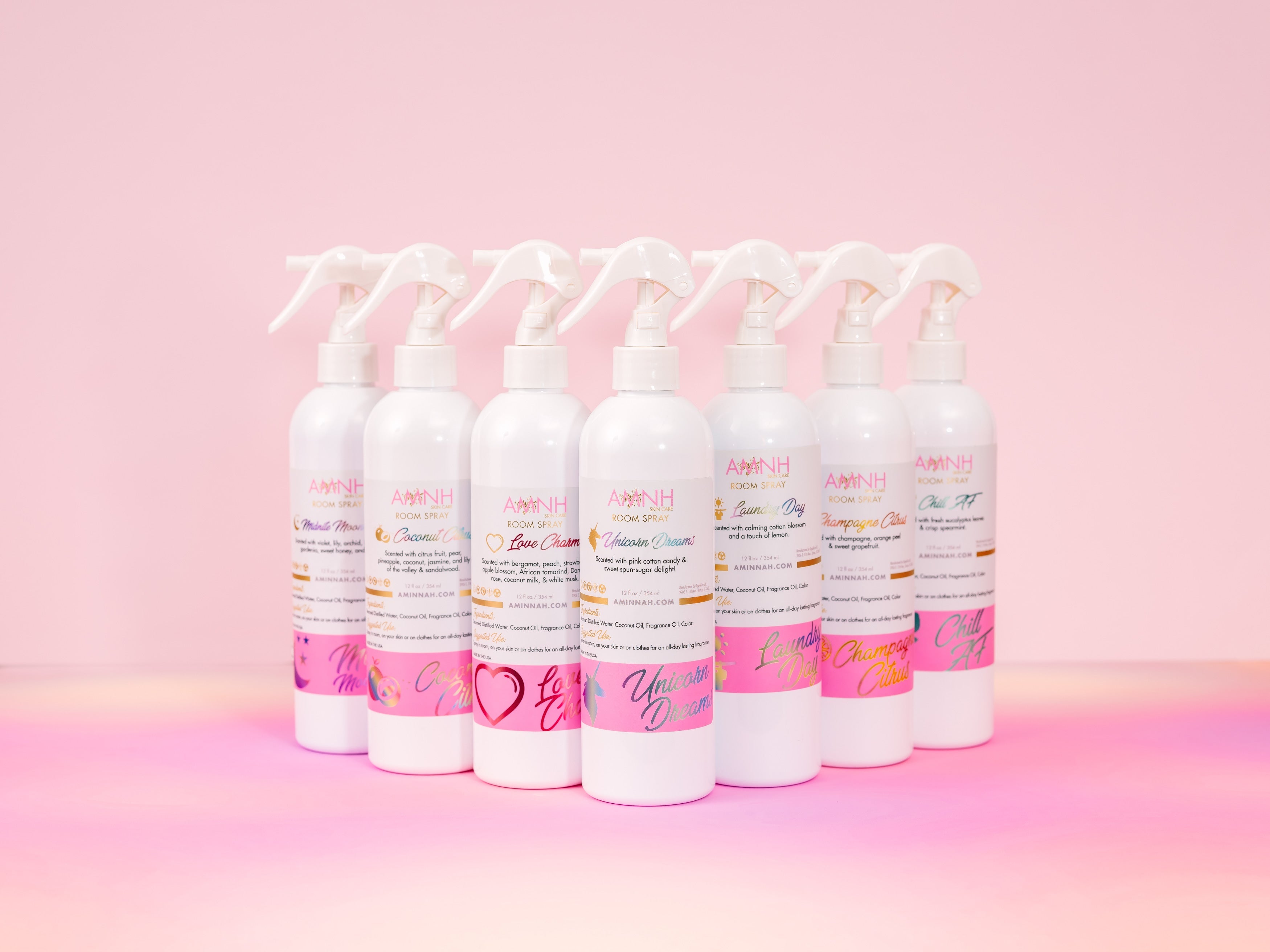 Unicorn Dreams Room Spray by AMINNAH displayed with multiple spray bottles on a soft pink background. This clean beauty home fragrance is crafted with natural ingredients and is vegan, cruelty-free, paraben-free, and gluten-free. Packaged in recyclable bottles by a female-owned brand, it adds a fresh, inviting scent to any room while reflecting a commitment to conscious, eco-friendly living.