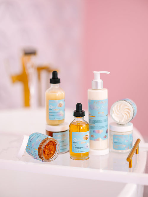 Natural skincare collection displayed on a bathroom sink featuring eczema cream, serum, sugar scrub, body oil, cleanser, and lotion in clean beauty packaging from a cruelty-free, vegan, female-owned brand.