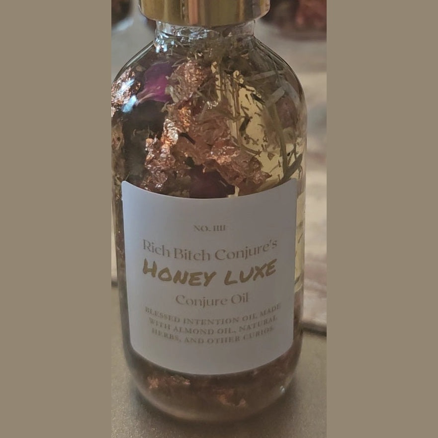 Bottle of 'Honey Luxe' Conjure Oil with a gold cap on a neutral background