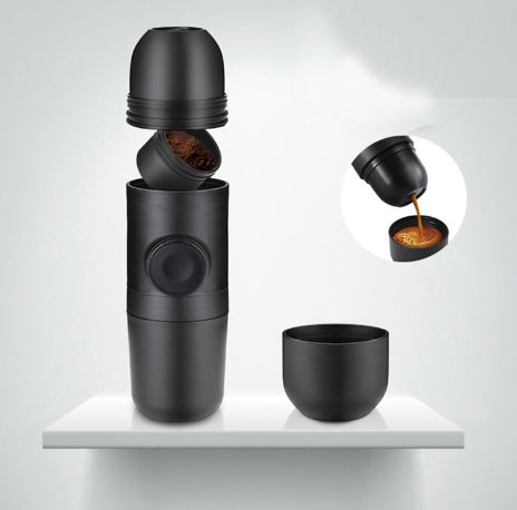 Portable manual mini espresso coffee maker in black with compact handheld design, 8-bar pressure, compatible with ground coffee or coffee capsules, ideal for travel, camping, hiking, office, and home use.