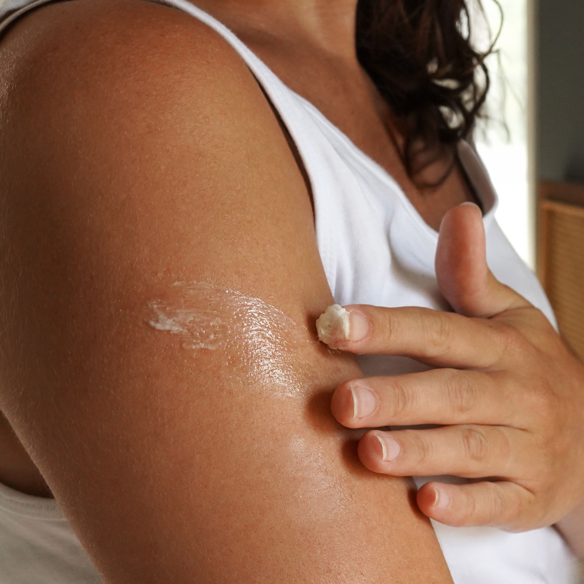 Person applying Grazly Whipped Regenerative Tallow & Magnesium Balm to the upper arm, demonstrating smooth application of the whipped moisturizing balm for daily skin hydration and nourishment.