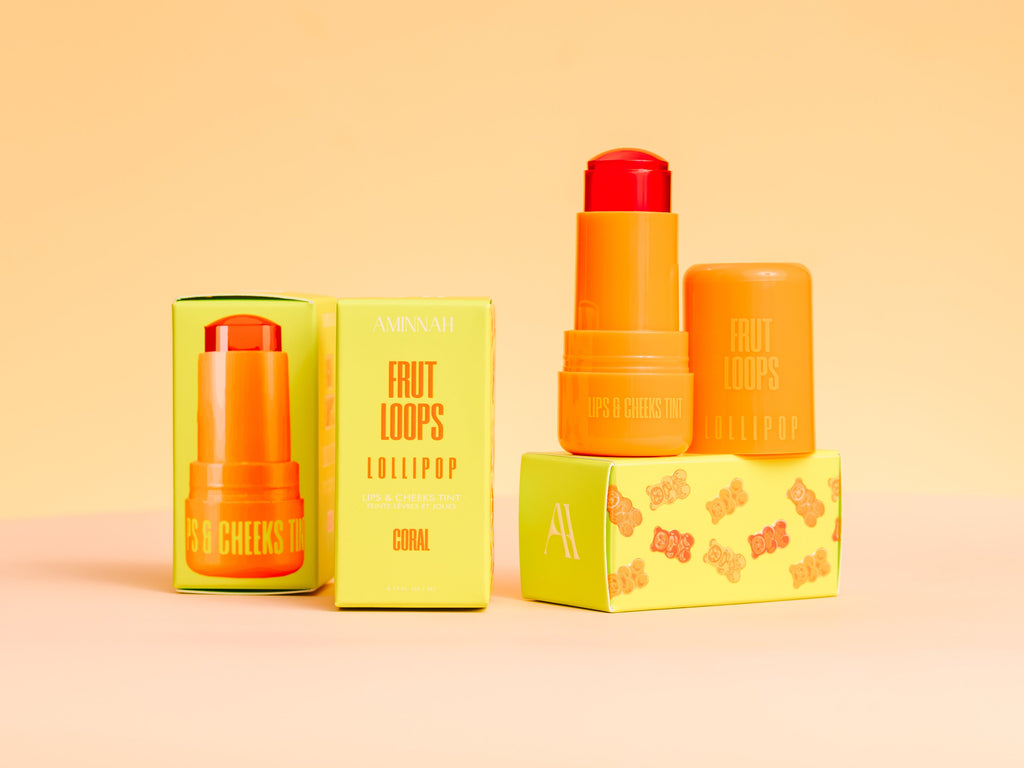 Fruit Loops LOLLIPOP Lips & Cheeks Tint in Coral by Aminnah displayed with packaging and open tint stick, clean beauty lip and cheek tint made with natural ingredients, cruelty free, vegan, female owned brand, nourishing multi-use makeup for a fresh radiant glow.