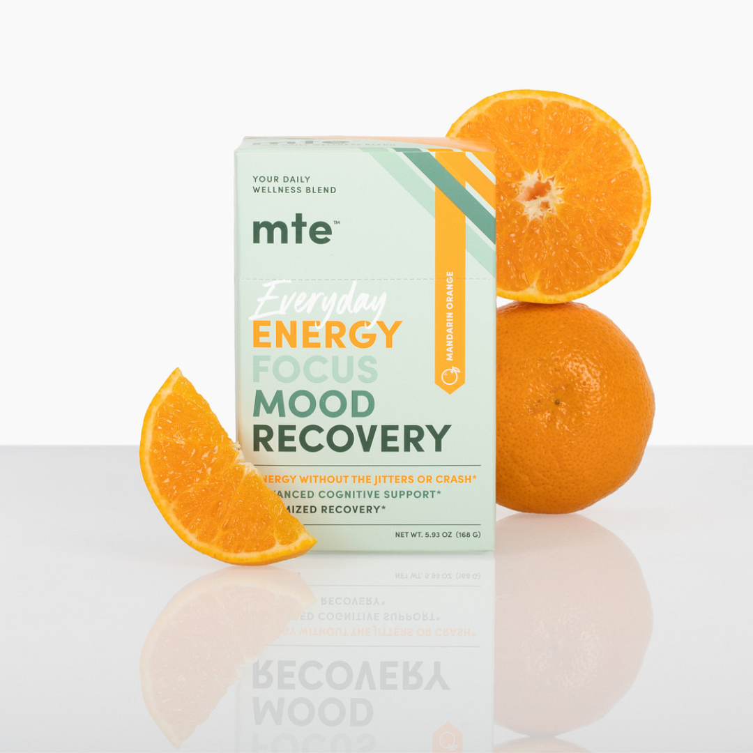 Box labeled 'mte' with text 'Energy Focus Mood Recovery' surrounded by oranges on a reflective surface.