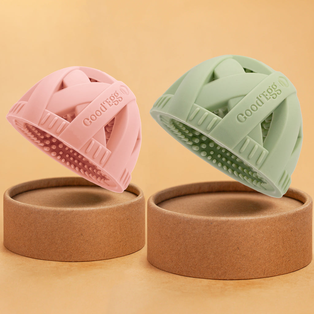 GoodEgg™ Flock Momma 2-Pack silicone egg cleaning brushes in blush pink and sage green, featuring flexible scrubbing nubs for cleaning eggs with a beige background.