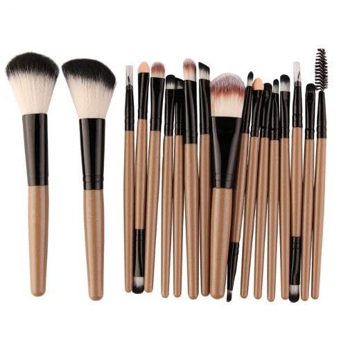 Set of makeup brushes with light brown handles and black bristles on a white background