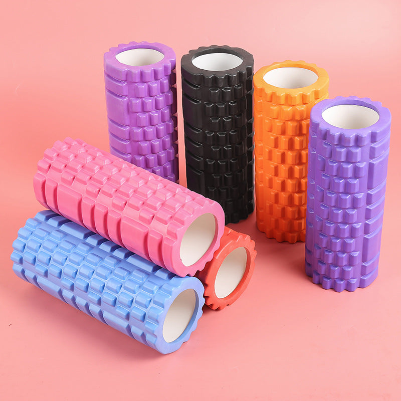 Set of colorful foam rollers on a pink background
