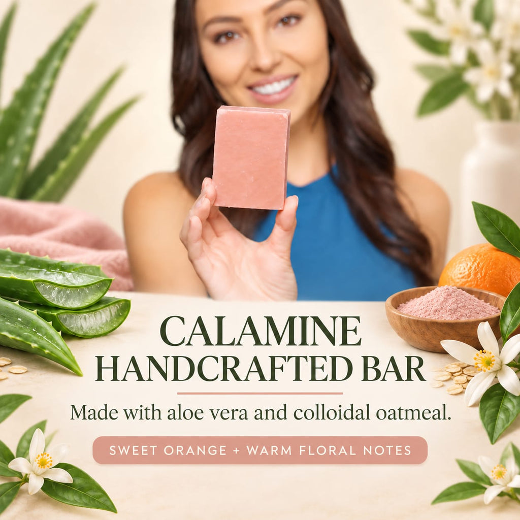 A smiling woman holds up a rectangular pink bar of soap in front of a styled background with aloe vera leaves, white flowers, and an orange. Large text reads 'CALAMINE HANDCRAFTED BAR' with smaller text 'Made with aloe vera and colloidal oatmeal' and 'SWEET ORANGE + WARM FLORAL NOTES'.