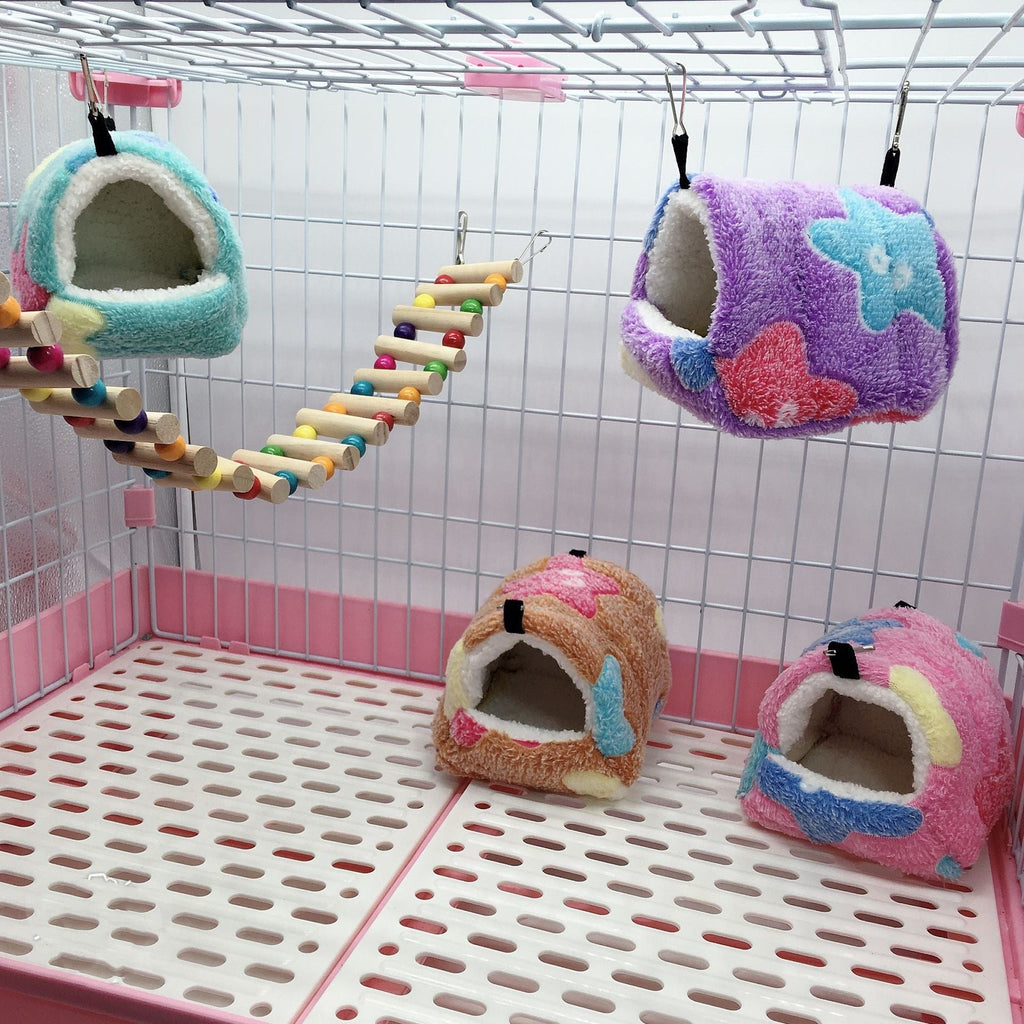 Cozy plush hamster sleeping huts hanging inside a small pet cage with a colorful wooden ladder, providing warm hideaway nests for hamsters, mice, gerbils, and other small pets.