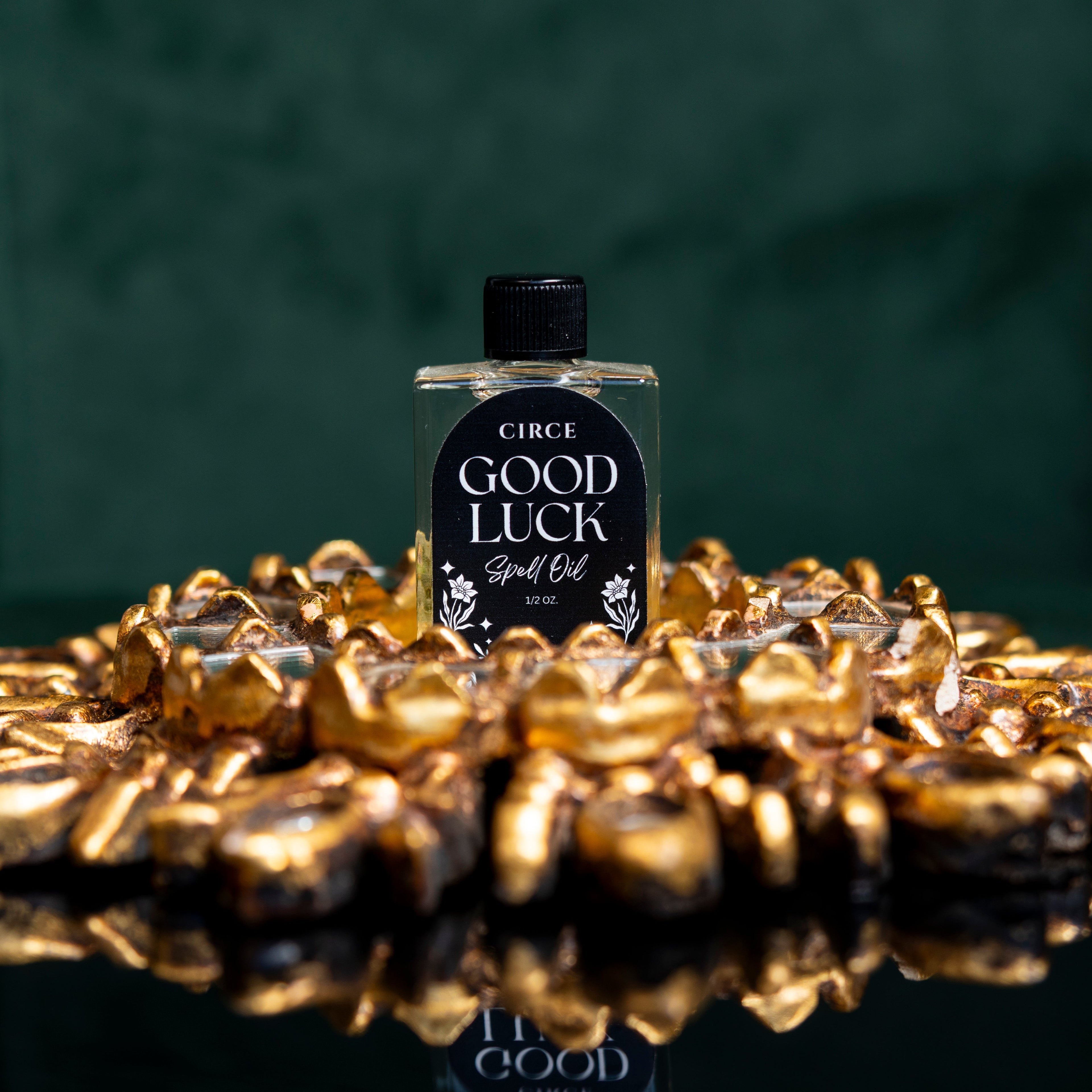 Circe Good Luck Ritual Spell Oil for fortune, prosperity, abundance, success, positive energy, manifestation and opportunity, 1/2 oz bottle displayed on decorative gold stones