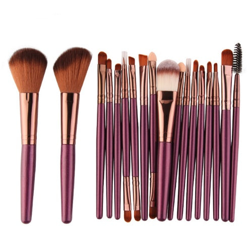 Set of makeup brushes with purple handles on a white background