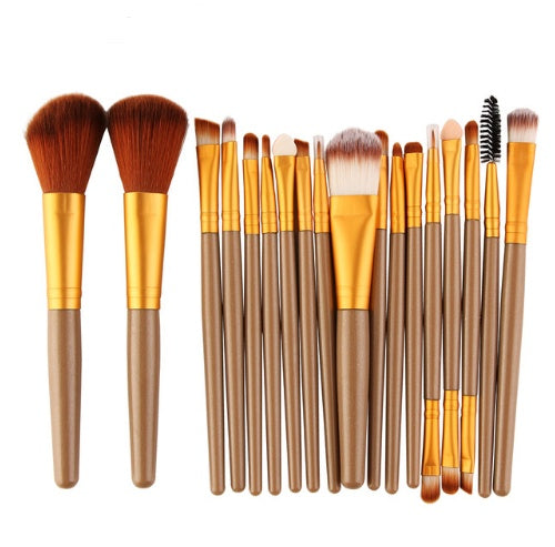 Set of makeup brushes with brown and gold handles on a white background