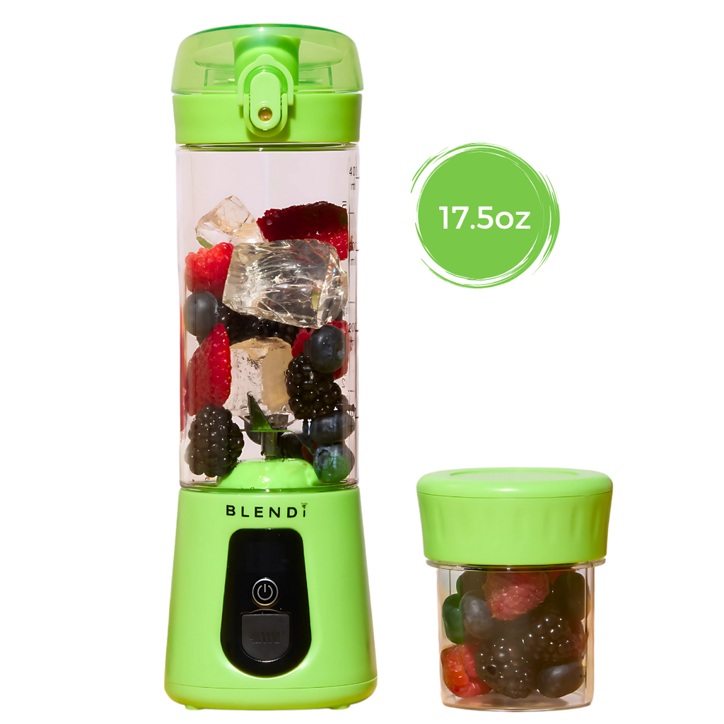 Light Green portable blender with fruit inside on a white background