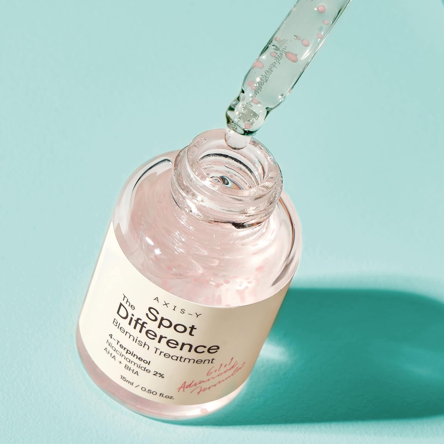 AXIS-Y Spot The Difference Blemish Treatment bottle with dropper dispensing serum into the bottle, showcasing pink ceramide capsules in a hydrating acne spot treatment.