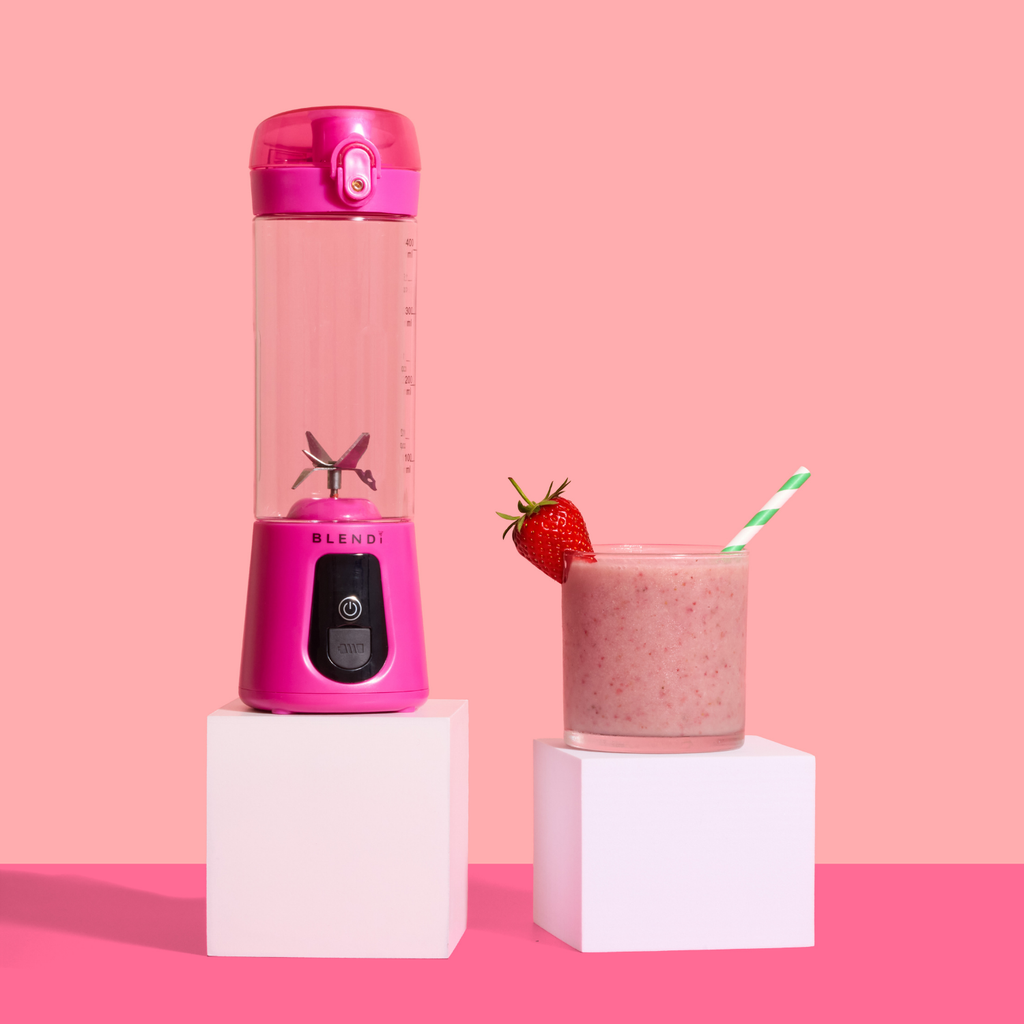Pro+ 17oz portable ice-crushing blender in pink with strawberry smoothie, powerful stainless steel blades and travel cup for smoothies, shakes and frozen drinks.