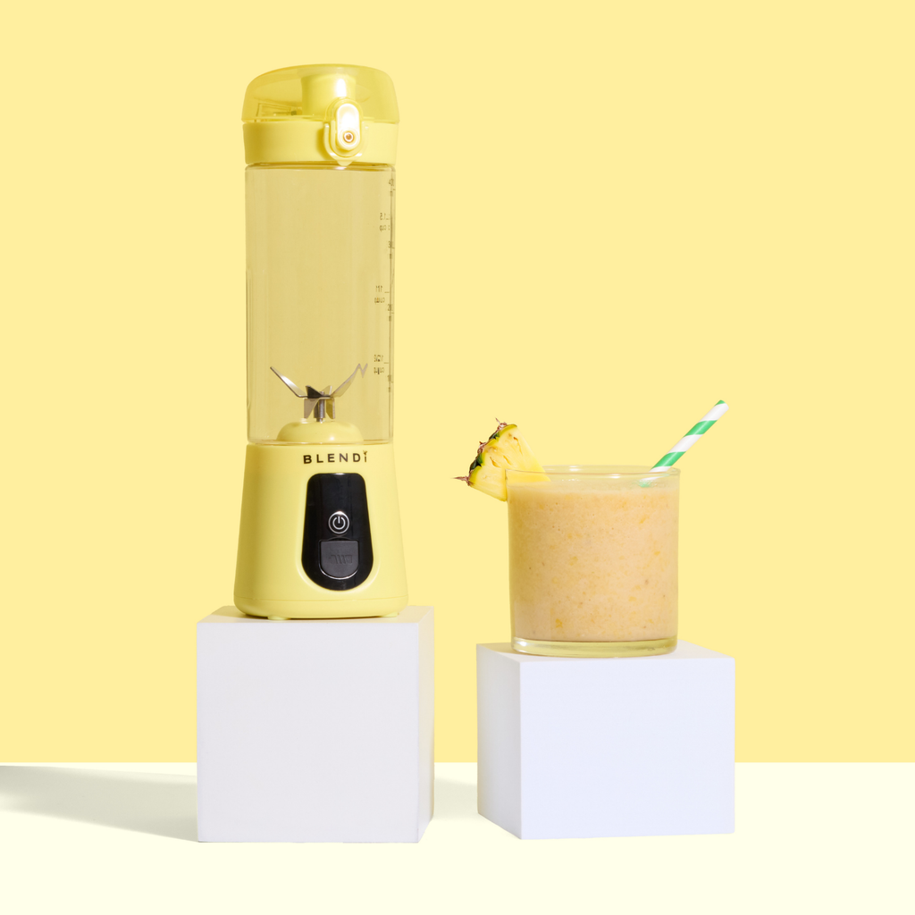 Yellow Pro+ 17oz portable ice-crushing blender beside a pineapple smoothie, ideal for smoothies, shakes, juices and frozen drinks.