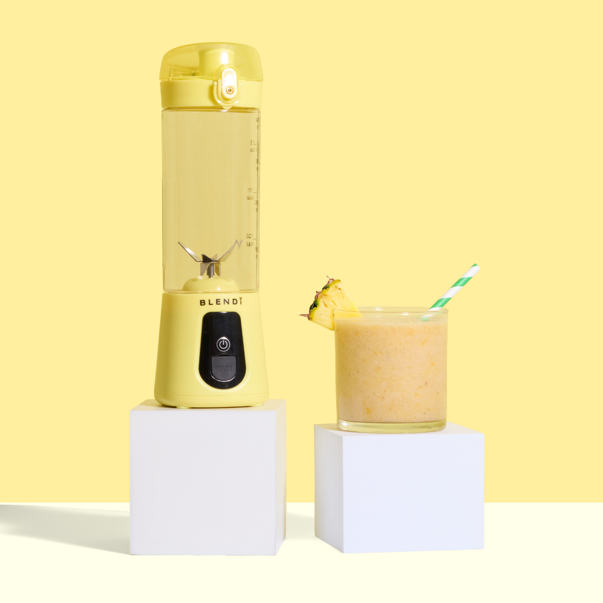 Yellow Pro+ 17oz portable ice-crushing blender beside a pineapple smoothie, ideal for smoothies, shakes, juices and frozen drinks.