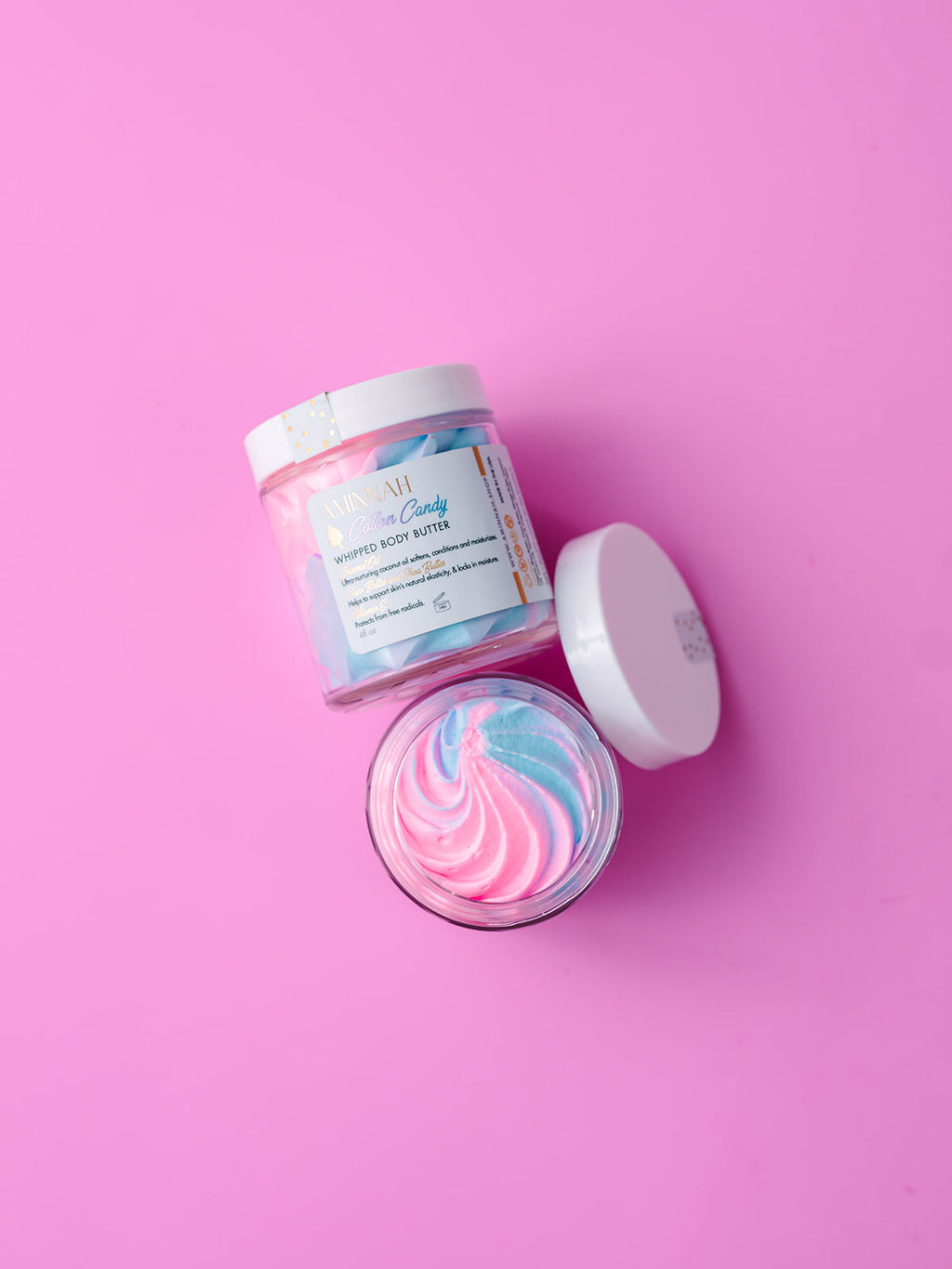 AMINNAH Cotton Candy Whipped Body Butter with pastel pink and blue whipped texture in a luxury skincare jar. Clean beauty body moisturizer made with natural ingredients that help nourish, soften, and hydrate dry skin. Vegan, cruelty free, paraben free, gluten free formula in recyclable packaging from a female owned brand, perfect for everyday self-care and silky-smooth, healthy-looking skin.
