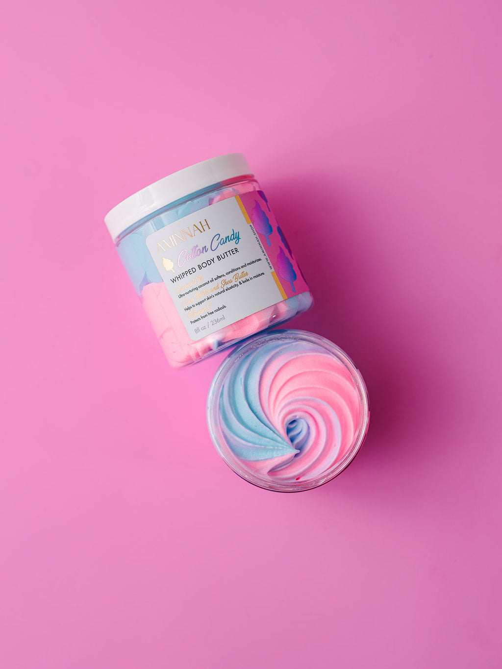 AMINNAH Cotton Candy Whipped Body Butter with luxurious pastel pink and blue whipped texture in an elegant jar. Clean beauty body moisturizer made with natural ingredients, vegan, cruelty-free, paraben-free, and gluten-free formula for deeply nourished, silky-soft skin. Crafted by a female-owned brand using recyclable packaging for conscious, luxurious self-care.