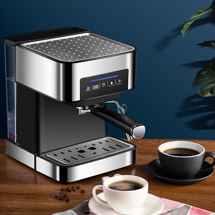 Compact stainless steel espresso machine with touch controls, removable water tank, steam milk frother, and two cups of freshly brewed coffee on a wooden table.