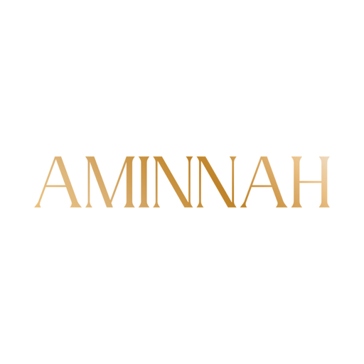 AMINNAH logo in elegant metallic gold serif lettering on a clean white background, representing a female-owned clean beauty brand specializing in vegan, cruelty-free skincare made with natural ingredients. Committed to paraben-free formulas, gluten-free skincare, recyclable packaging, premium self-care, and luxurious beauty products.