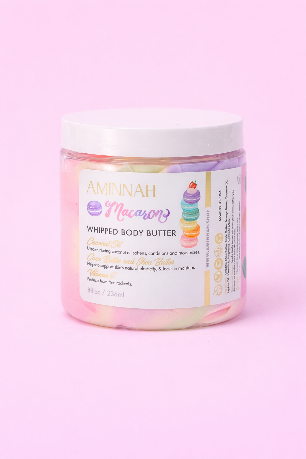 AMINNAH Macaron Whipped Body Butter in an 8 oz jar displayed on a soft pink background. This rich, whipped moisturizer is inspired by the sweet scent of French macarons and is crafted with nourishing botanical butters and plant oils to deeply hydrate, soften, and smooth dry skin. Clean beauty, cruelty-free, vegan, and made with naturally inspired ingredients by a female-owned brand. Available at Tree of Life Grocers.