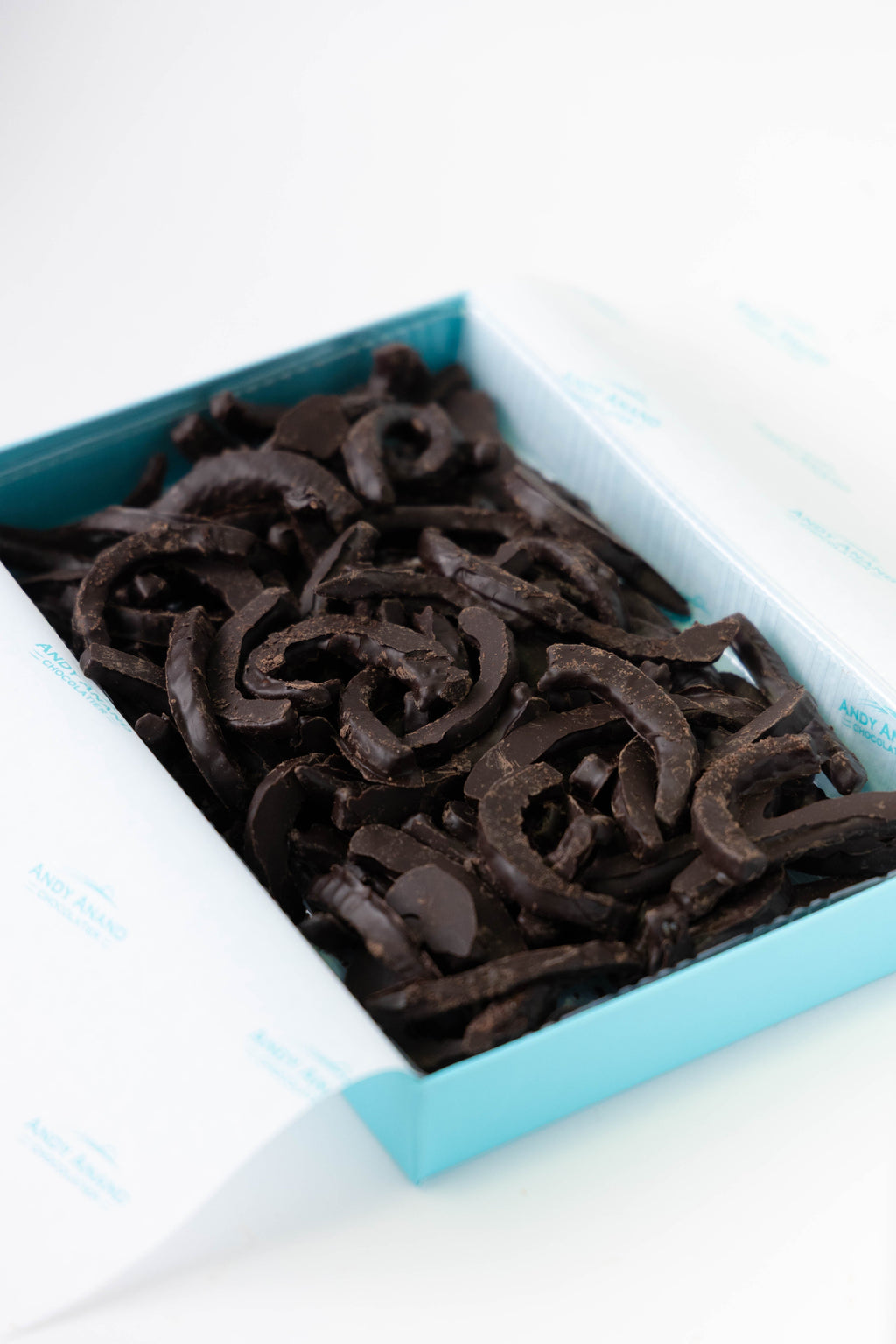 Dark chocolate candy in a blue and white dish on a white background