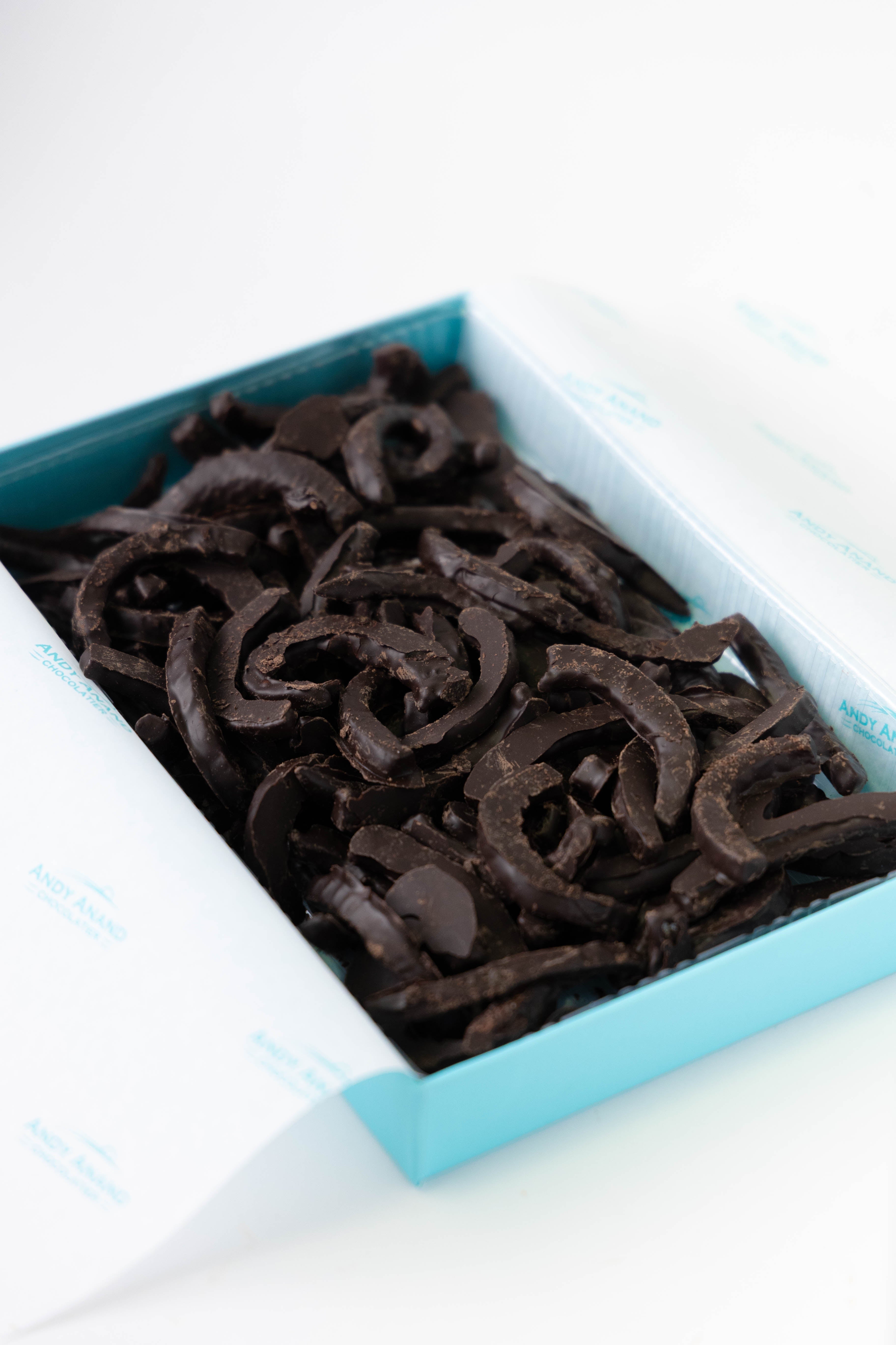 Dark chocolate candy in a blue and white dish on a white background