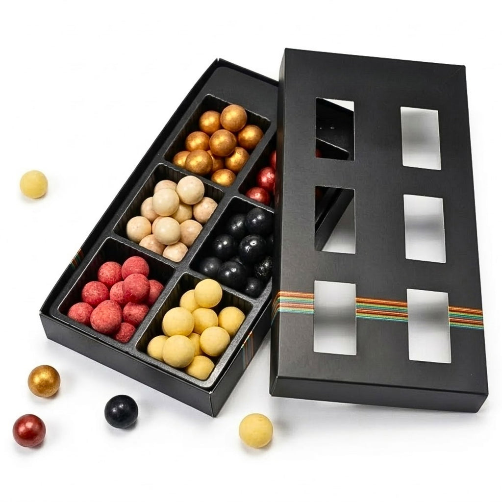 Black chocolate box with compartments filled with assorted chocolates on a white background
