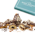 Chocolate-dipped pastries with nuts on a white surface, Andy Anand Chocolatier box in the background.