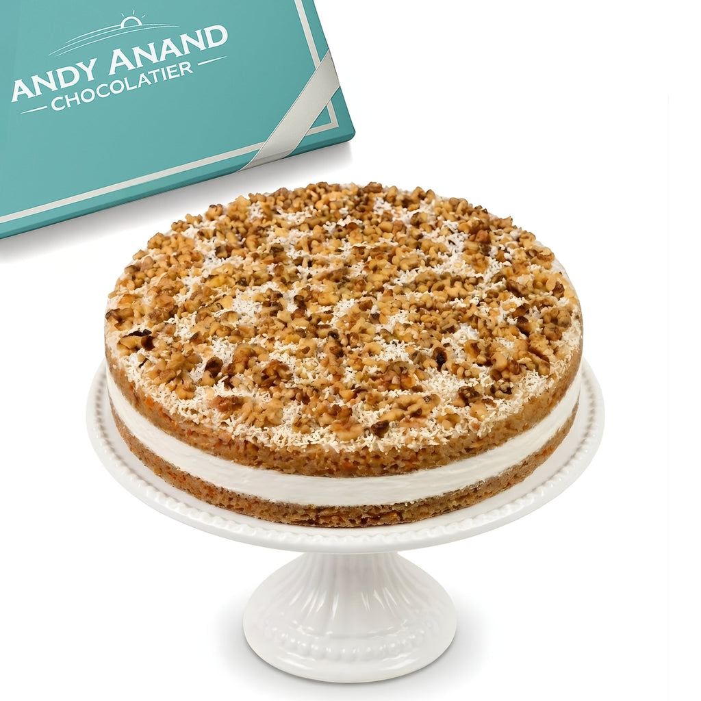 Layered cake with a white stand and Andy Anand Chocolatier box in the background