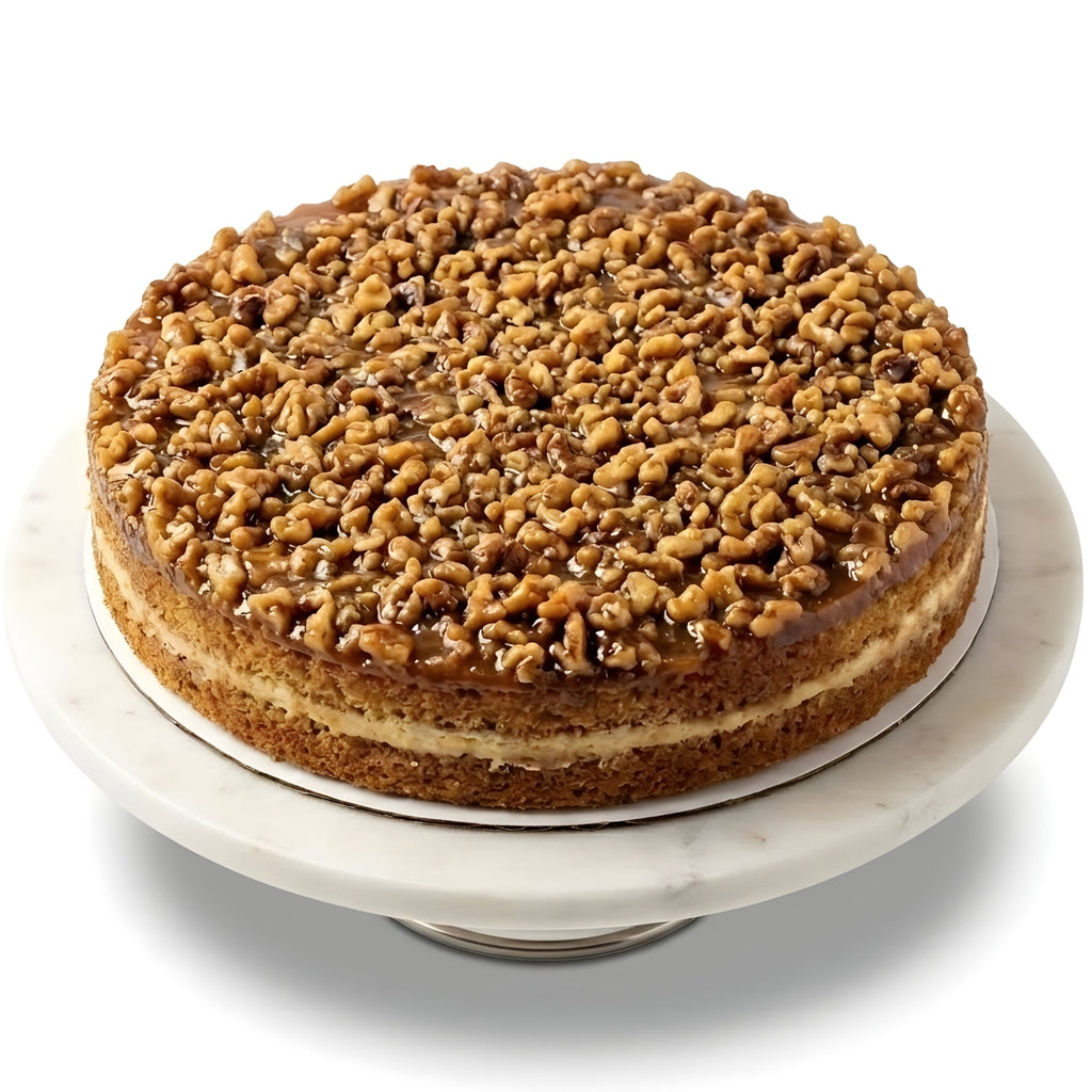 Cake with a crumbly topping on a marble stand against a white background