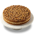 Cake with a crumbly topping on a marble stand against a white background