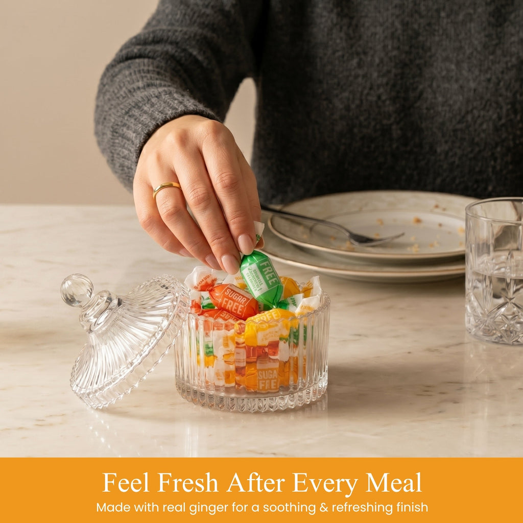 Person adding a green bottle to a glass container of candy on a table.