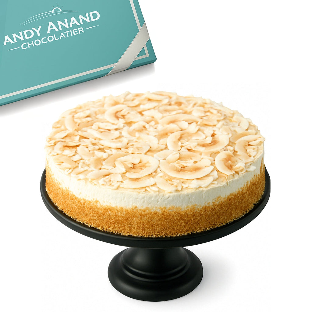 Cheesecake on a black stand with 'Andy Anand Chocolatier' branding in the background.