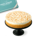 Cheesecake on a black stand with 'Andy Anand Chocolatier' branding in the background.